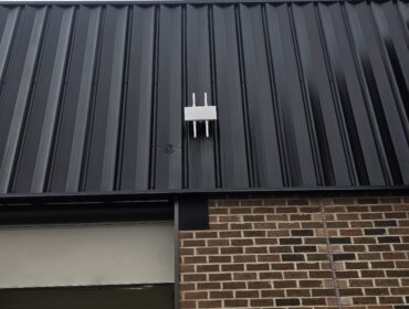 Wireless network equipment mounted to a commercial ceiling.